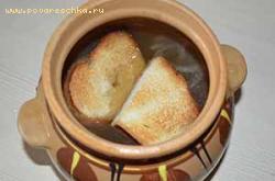 Готовый суп перелить в жаропрочную посуду и уложить сверху поджаренный хлеб