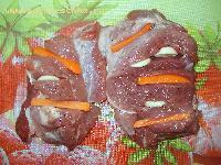 2) Сделать в свинине небольшие разрезы, заполнить углубления морковкой и чесноком